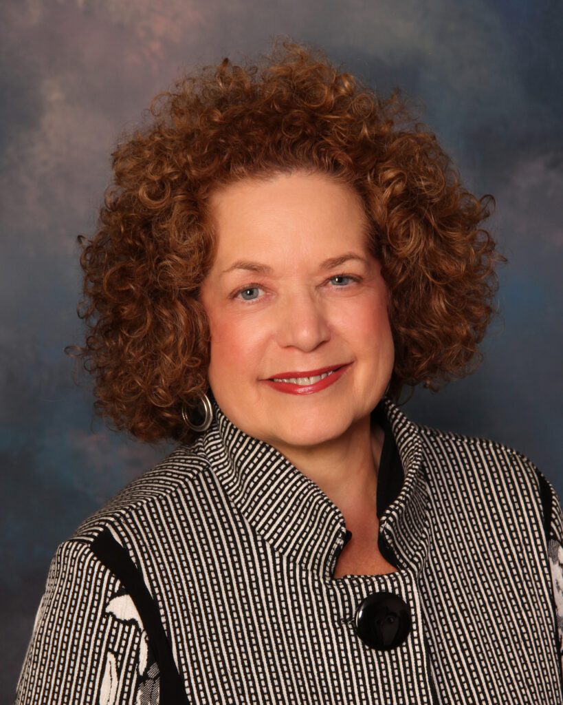 A woman with curly hair and a black and white shirt.